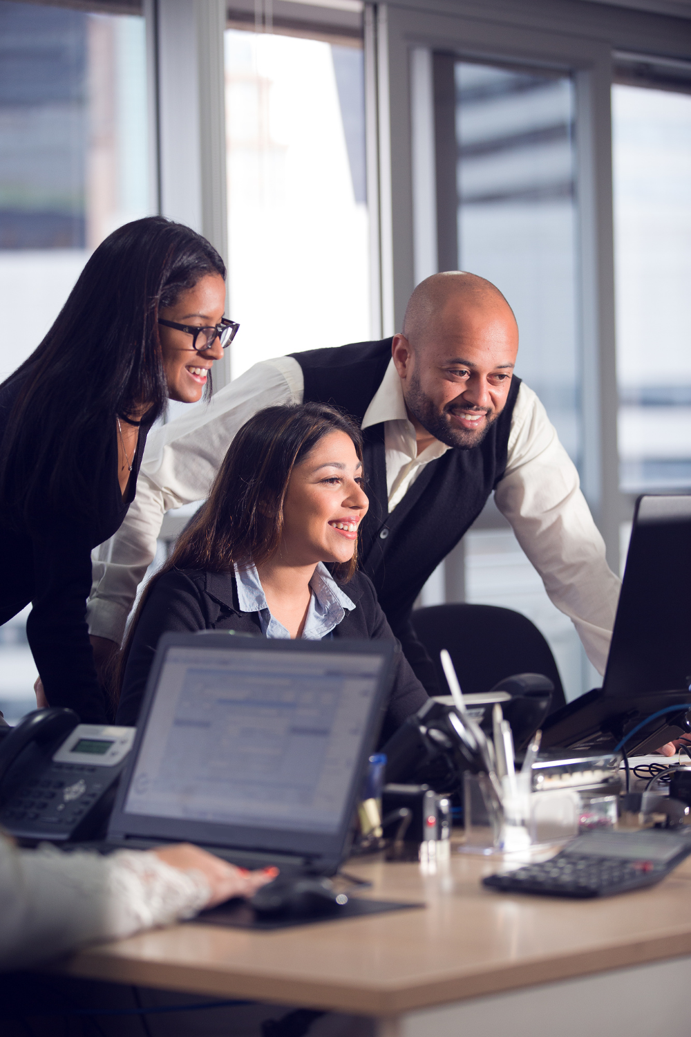 Three people looking at computer